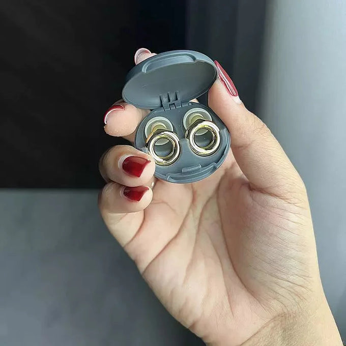 Hand holding a pair of Loop Switch 2 earplugs in the case